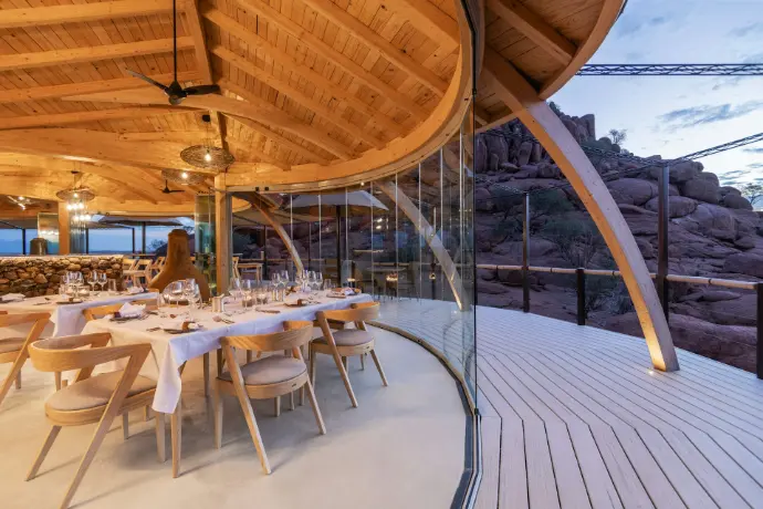 a restaurant with a wooden roof and a glass wall